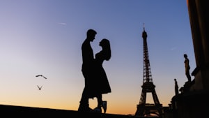 Silhouette d’un couple au coucher du soleil près de la tour Eiffel