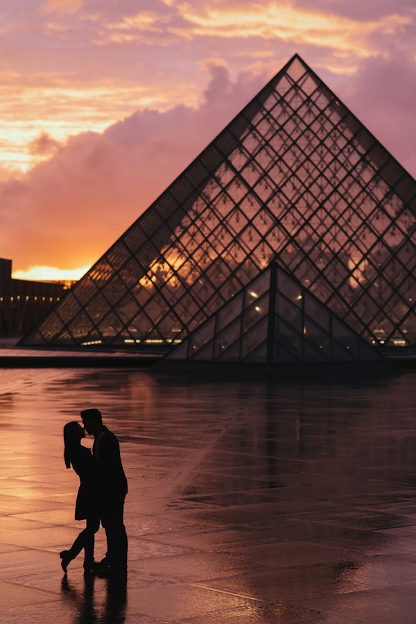 Couple photographié devant la pyramide du Louvre
